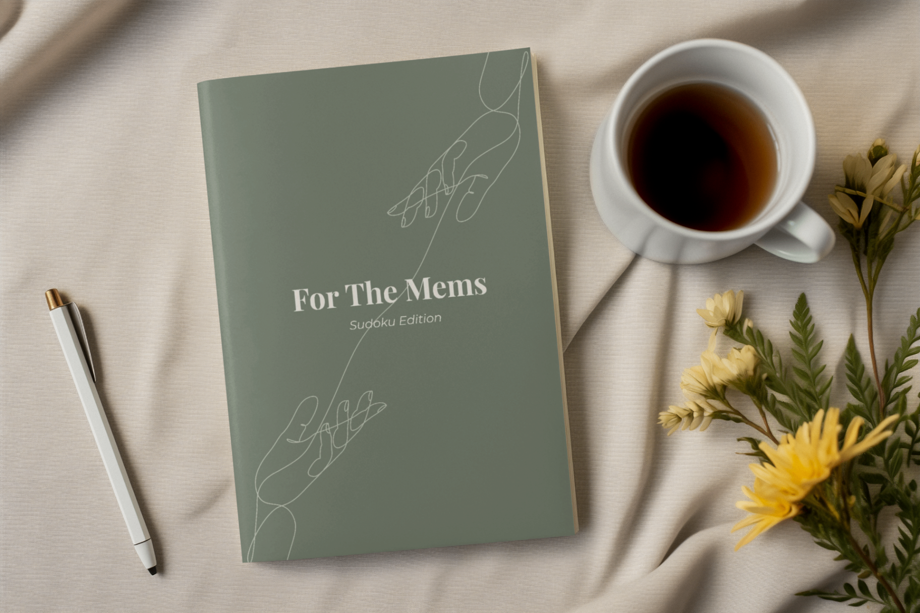 For The Mems: Sudoku Edition book resting on linen with coffee and dried flowers