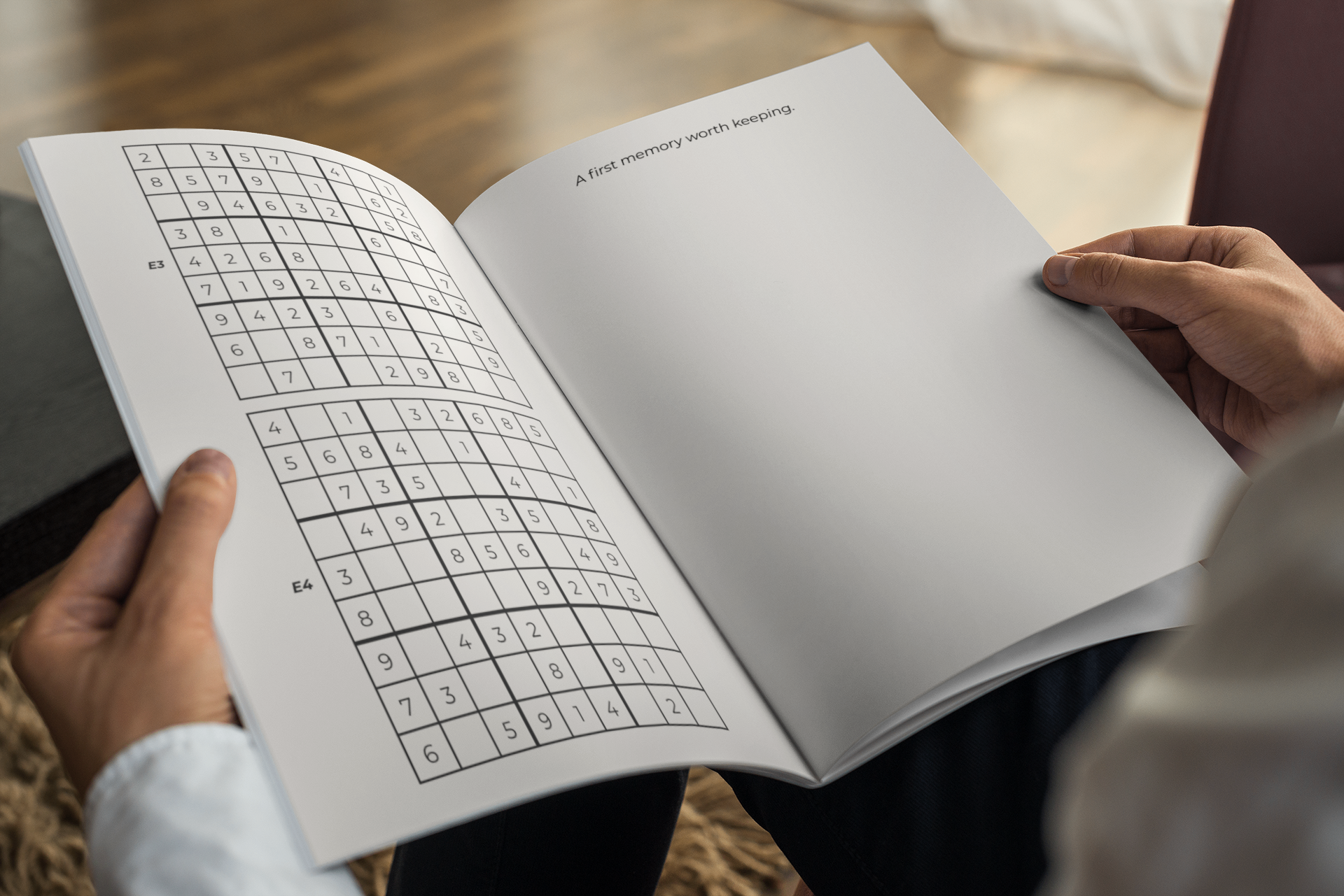 Hands holding the Sudoku Edition open to a puzzle spread and a photo prompt page